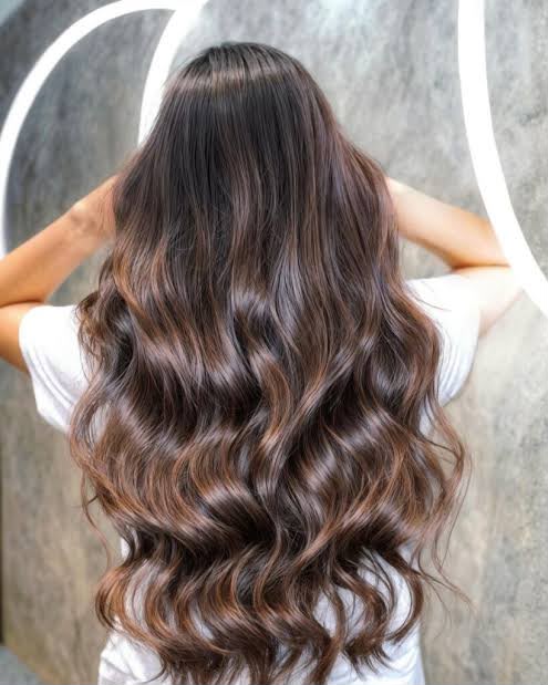 Long brunette waves with caramel dimension and extensions